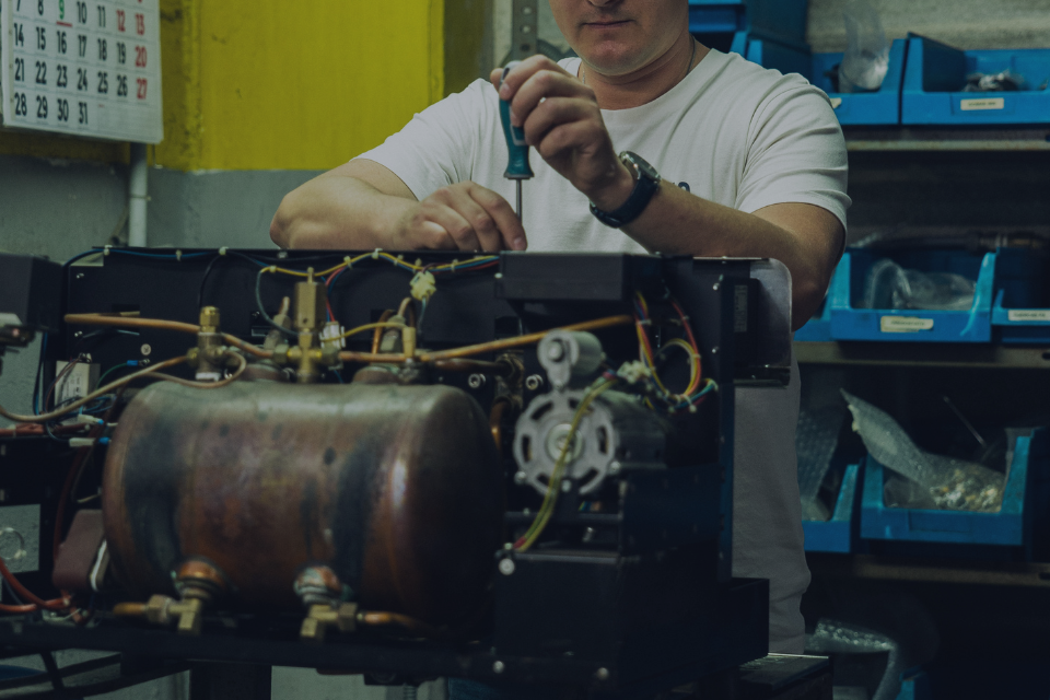 hombre reparando maquina de café en las instalaciones de sat ikari