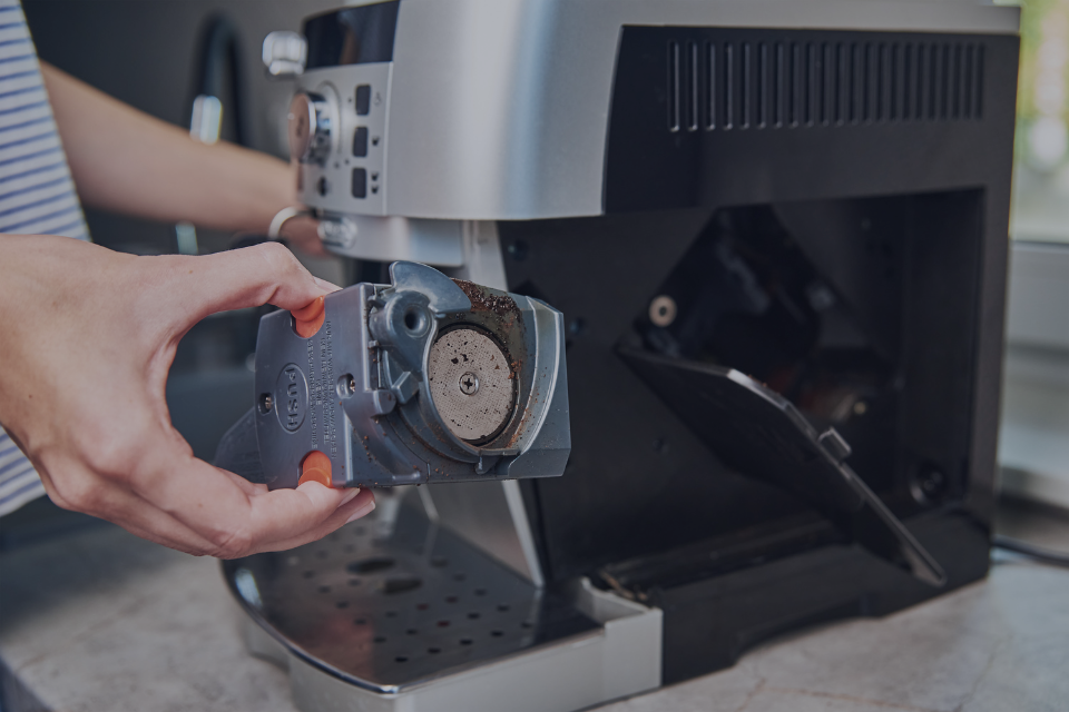 mano instalando compenente en maquina de café