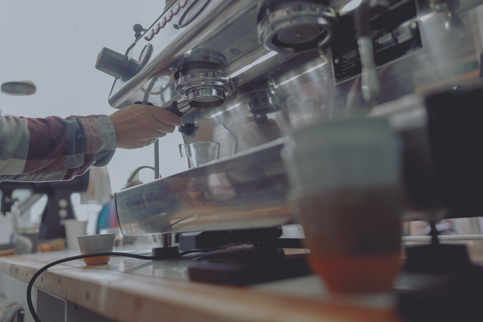 mano realizando un mantenimiento preventivo a una maquina de café